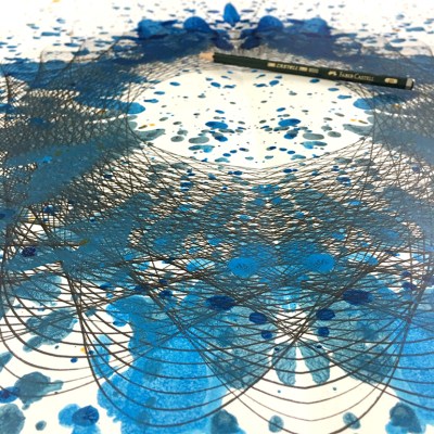 Angle view of "Blue Nebulae" ink blot painting by Mary Wagner. Black geometric ink drawing overplayed with a blue ink blot pattern.